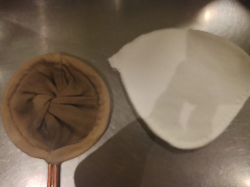 コーヒーの色が染み込んだ使用中のネルフィルターと、新品の白いネルフィルターの比較