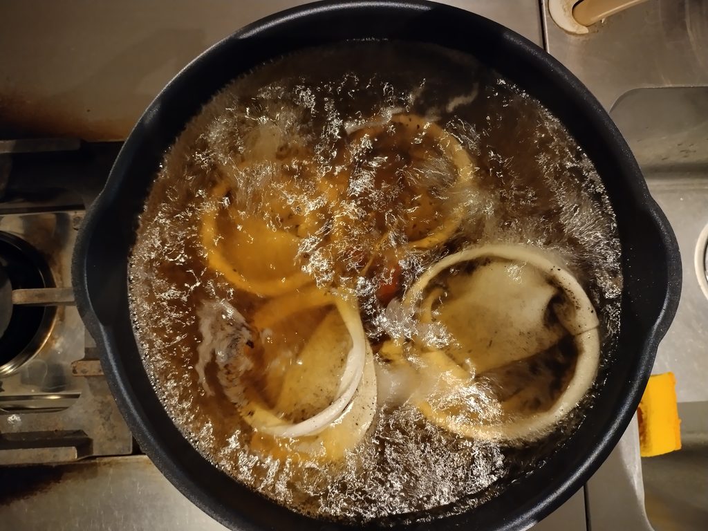 沸騰した湯の中で、コーヒー色に染まりながら煮えているネルフィルター