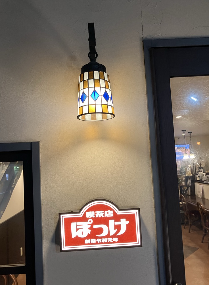 入口のステンドグラスのランプと看板