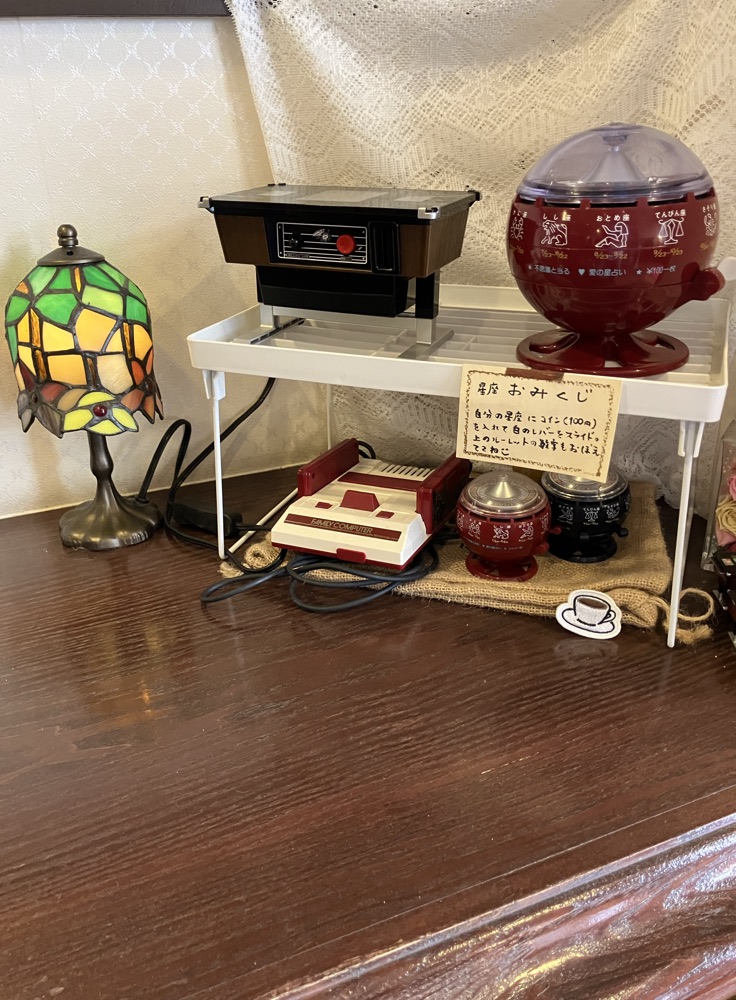 店内に置いてあるルーレット式おみくじ器とレトロな小物