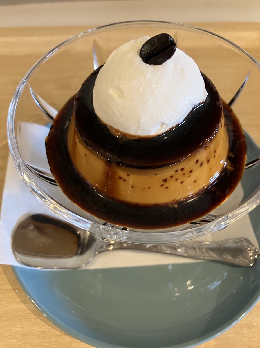 喫茶店ぽっけの自家製プリン。生クリームとコーヒー豆をのせたかためのプリン