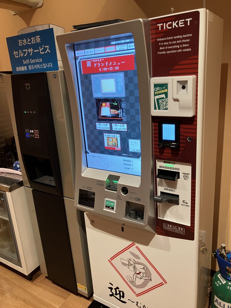 迎〜むかえる〜の券売機とセルフサービスのお茶